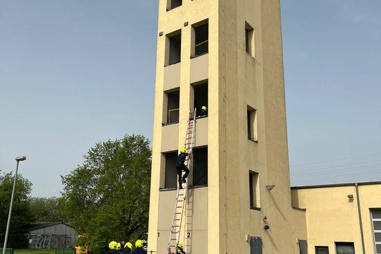 Feuerwehrmänner üben am Schlauchturm mit Leitern